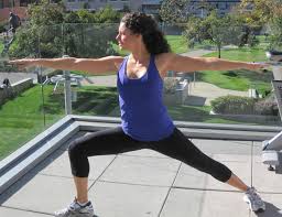 Person on yoga mat doing the yoga pose Warrior II.